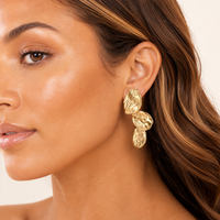 Model wearing Alouette gold sculptural statement earrings