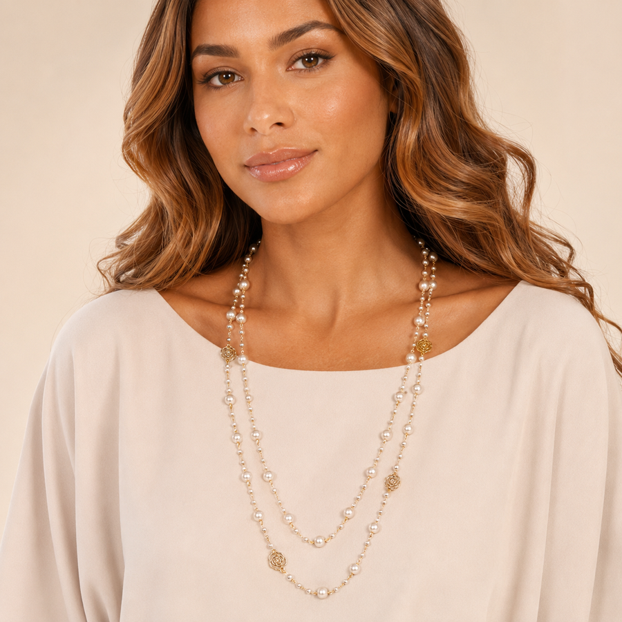 Model wearing long pearl necklace with gold rose charms